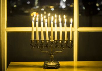 חנוכה - חנוכיה דולקת משתקפת בחלון